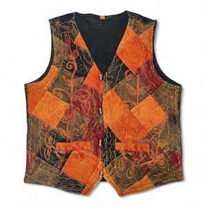 May include: A patchwork waistcoat with a V-neck and wooden buttons. The waistcoat features a variety of orange, brown, and black squares with embroidered floral designs. The waistcoat has two pockets and a black back.
