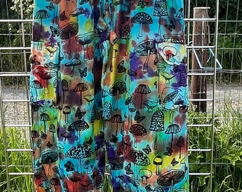 May include: Tie-dye trousers with a mushroom and butterfly print. The trousers have a drawstring waist and two cargo pockets.
