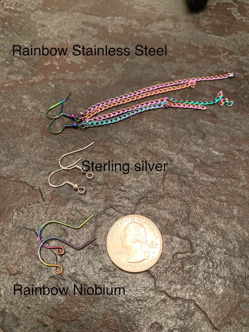May include: Three pairs of earrings with different hook styles and finishes. The top pair is rainbow stainless steel, the middle pair is sterling silver, and the bottom pair is rainbow niobium.