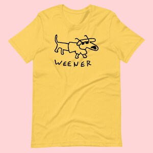 May include: Yellow short-sleeved t-shirt with a black cartoon dachshund wearing sunglasses and the word "WEENER" printed below.