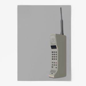 Pode incluir: Um telefone celular vintage bege, estilo tijolo, com uma antena preta e um teclado. O telefone está em um fundo cinza.