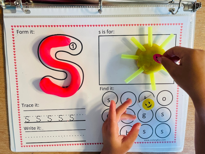May include: A printable worksheet for learning the letter 'S'. The worksheet includes a tracing activity, a 'find it' activity, and a 'form it' activity using playdough. The 's is for' section shows a yellow sun with yellow straws.
