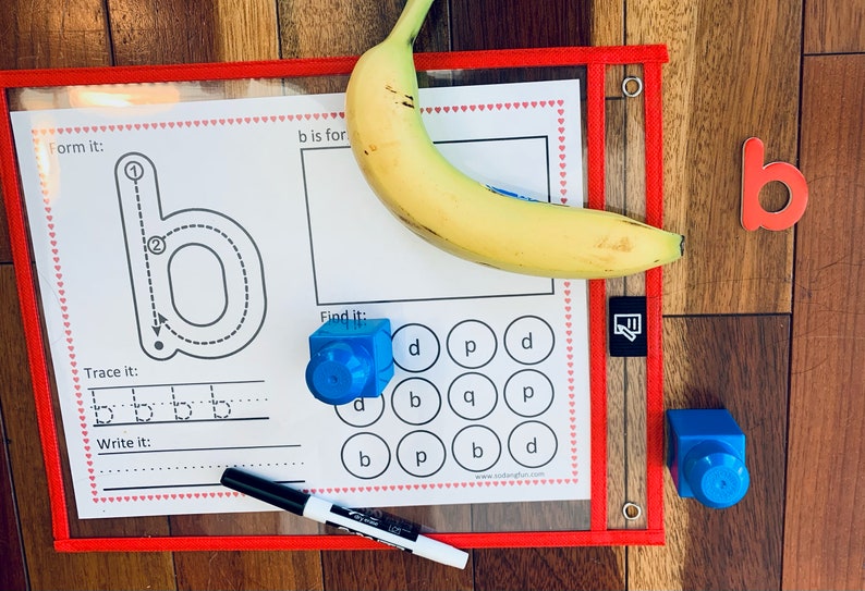 May include: A printable worksheet for learning the letter 'b'. The worksheet includes a tracing activity, a 'form it' section with arrows showing the stroke order, a 'find it' section with a grid of letters, and a 'write it' section with lines for practicing writing the letter. A banana, a blue block, and a red letter 'b' are also shown.