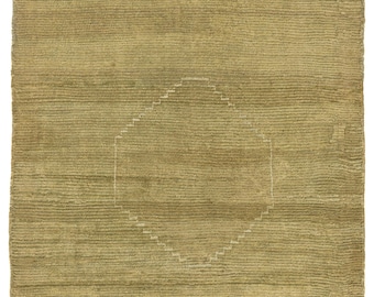 Op de afbeelding: Een vierkant, olijfgroen tapijt met een getextureerd, geribbeld oppervlak. Een geometrisch, ruitvormig ontwerp is gecentreerd op het tapijt, omlijnd in een lichtere tint. Het ontwerp van het tapijt is eenvoudig en modern, geschikt voor diverse interieurstijlen.