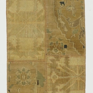 May include: A rectangular, patchwork rug with a neutral color palette of beige, brown, and tan. The rug is composed of several rectangular pieces sewn together, each with a unique pattern. The patterns include geometric shapes and floral motifs.