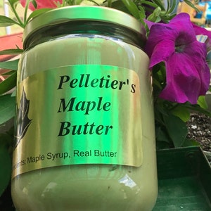 May include: A glass jar of Pelletier's Maple Butter with a gold label. The label reads "Pelletier's Maple Butter" and "Ingredients: Maple Syrup, Real Butter".