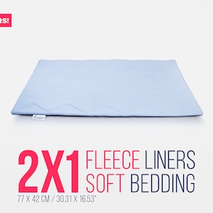 Puede incluir: Dos forros de forro polar azul claro para la cama de mascotas. Los forros miden 77 cm por 42 cm. El texto "2X1 FLEECE LINERS SOFT BEDDING" está impreso en rojo sobre un fondo blanco.