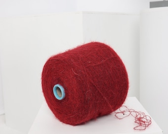 Pode incluir: Uma bobina de fio vermelho com um centro azul. O fio é macio e felpudo.