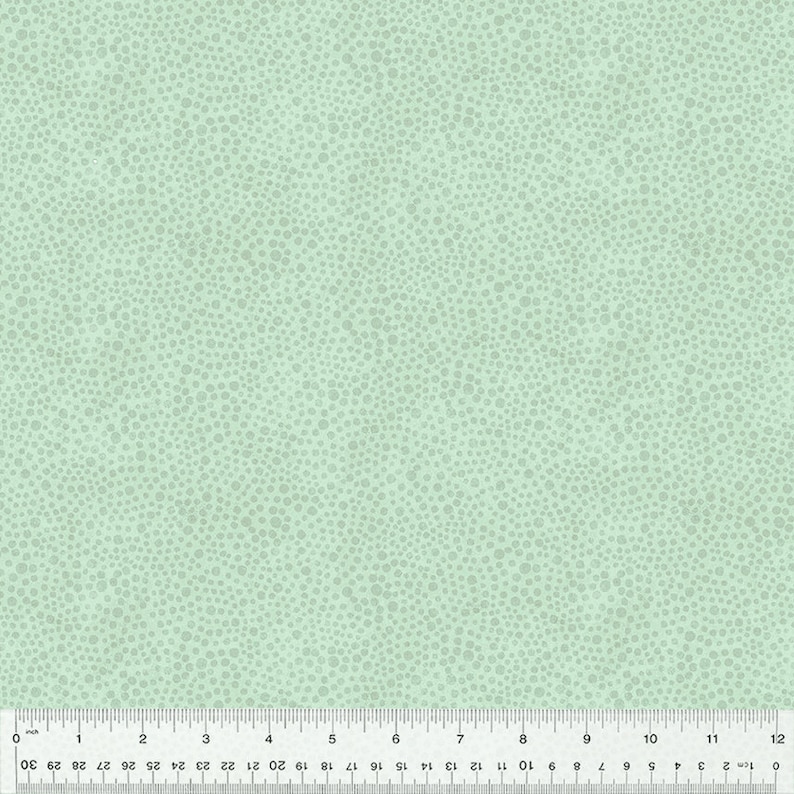 May include: A light green fabric with a subtle pattern of tiny white dots. The fabric has a smooth texture and a slightly textured surface.