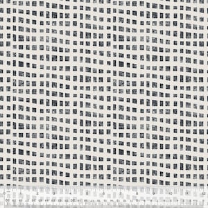 May include: A white fabric with a black and white geometric pattern of squares. The squares are arranged in a wavy pattern.