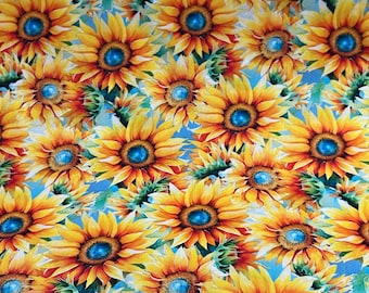 May include: A seamless fabric pattern featuring a close-up of bright yellow sunflowers with blue centers against a light blue background.
