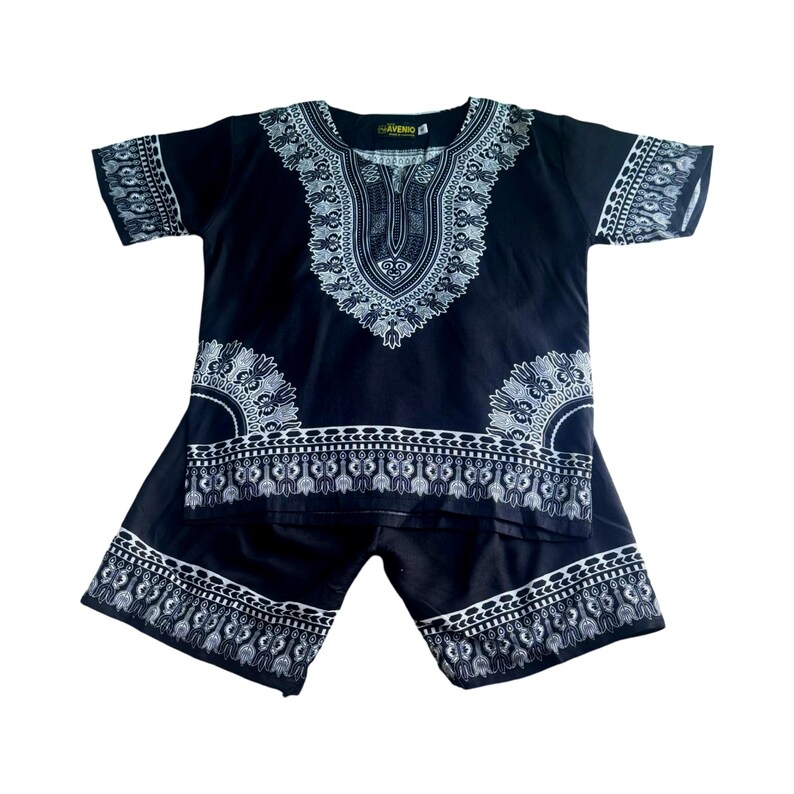 Puede incluir: Conjunto de camisa y pantalones cortos de estilo dashiki en negro y blanco con un patr&oacute;n geom&eacute;trico. La camisa tiene un cuello redondo y mangas cortas. Los pantalones cortos tienen una cintura el&aacute;stica.