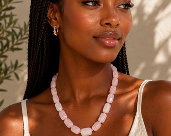 May include: A necklace featuring a single strand of polished, light pink, rectangular-shaped rose quartz beads. The beads are uniform in size and strung together to form a classic collar-style necklace that rests against the base of the neck.