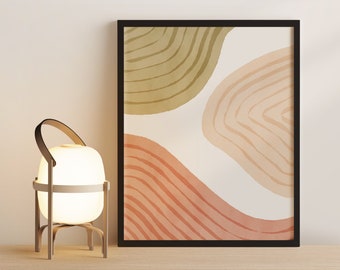 May include: A framed abstract print with a white background and three overlapping shapes in shades of green, peach, and orange. The shapes have a watercolour-like texture and are outlined in black. The print is hanging on a white wall above a wooden shelf with a small lamp.
