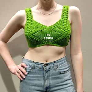 Könnte beinhalten: Ein limegrünes Häkel-Crop-Top mit V-Ausschnitt und einem Textetikett mit der Aufschrift "By Youths".