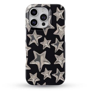 May include: A black smartphone case featuring a repeating pattern of metallic silver stars. The stars have a three-dimensional, inflated appearance with glossy highlights and shadows, creating a reflective effect against the solid black background.