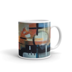 May include: A white ceramic mug with a colorful abstract design. The design features geometric shapes in shades of blue, orange, brown, and black.