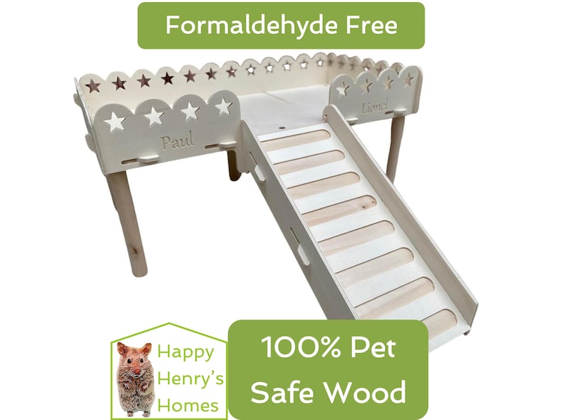 Puede incluir: Un h&aacute;bitat de h&aacute;mster de madera clara con un tobog&aacute;n, recortes en forma de estrella y los nombres "Paul" y "Lionel" grabados. Tambi&eacute;n se ve el texto "Formaldehyde Free" y "100% Pet Safe Wood". Dise&ntilde;ado para mascotas peque&ntilde;as.