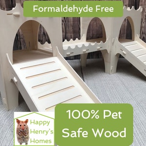May include: A white wooden hamster playhouse with two slides and a platform. The playhouse is made of 100% pet safe wood and is formaldehyde free. The text "Happy Henry's Homes" is on the bottom left corner of the image.