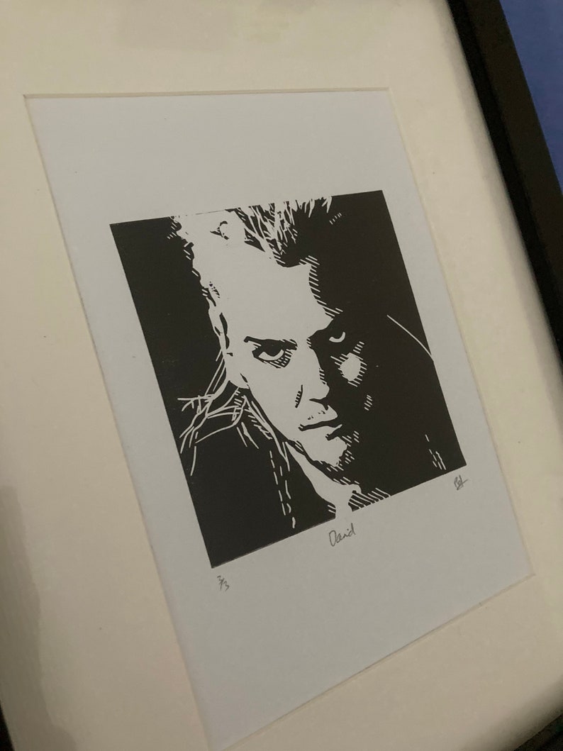 K&ouml;nnte beinhalten: Schwarz-wei&szlig;er Linolschnitt eines M&auml;nnergesichts. Der Druck ist signiert mit "David" und nummeriert mit "4/3".