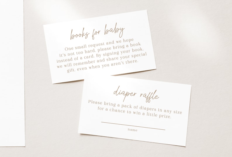 Puede incluir: Dos tarjetas blancas con texto marr&oacute;n. La tarjeta superior dice "libros para el beb&eacute;" y pide que se traiga un libro en lugar de una tarjeta. La tarjeta inferior dice "rifa de pa&ntilde;ales" y pide a los invitados que traigan un paquete de pa&ntilde;ales para tener la oportunidad de ganar un peque&ntilde;o premio.