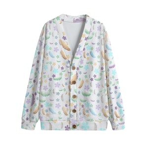May include: A white cardigan with a V-neck and button closure. The cardigan features a colorful pattern of feathers and flowers.