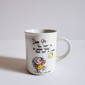 May include: White ceramic mug with a black and white illustration of a girl and a sun. The mug has the text "Dear God, You must be so happy today, Your sun is shining."