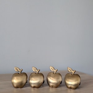 Może przedstawiać: Zestaw trzech ceramicznych kubków z nakrapianym, matowym wykończeniem. Kubki są w odcieniach kremu, jasnoszarości i ciemnoszarości. Każdy kubek ma prosty, minimalistyczny design i zaokrąglony uchwyt.