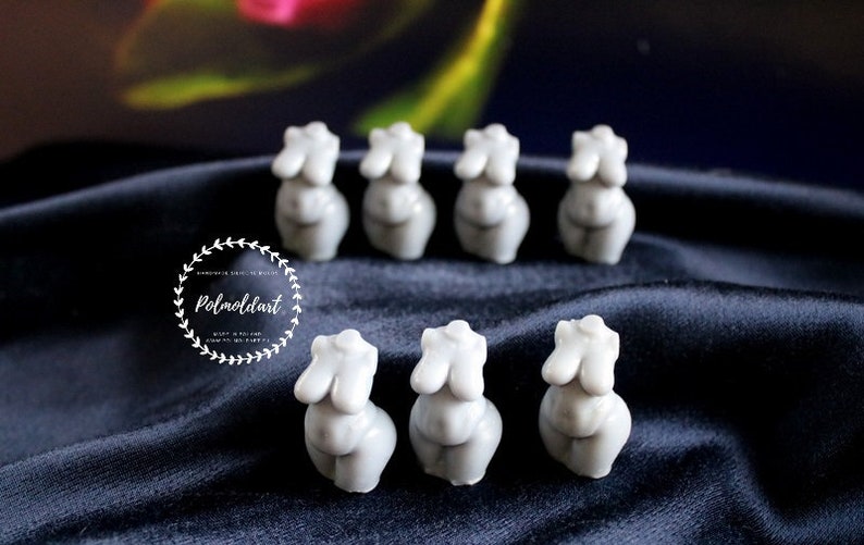 Puede incluir: Una colecci&oacute;n de peque&ntilde;as esculturas de torso femenino grises dispuestas sobre una superficie oscura y texturizada. Las esculturas est&aacute;n estilizadas y tienen formas redondeadas. La imagen incluye un logotipo con el texto "Polmoldart" en un dise&ntilde;o circular.