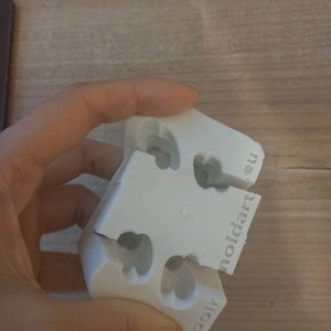 Puede incluir: Un molde blanco de tres partes con recortes en forma de coraz&oacute;n. El molde est&aacute; hecho de un material pl&aacute;stico duro y tiene el texto "moldart.eu" y "polr" impreso. El molde est&aacute; dise&ntilde;ado para crear objetos con forma de coraz&oacute;n.