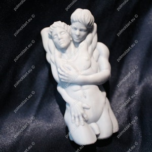 K&ouml;nnte beinhalten: Eine wei&szlig;e Skulptur, die zwei sich umarmende Figuren darstellt. Die Figuren sind nackt, wobei eine Figur die andere st&uuml;tzt. Die Skulptur ist vor einem dunklen Hintergrund platziert, der die Details der Figuren hervorhebt.