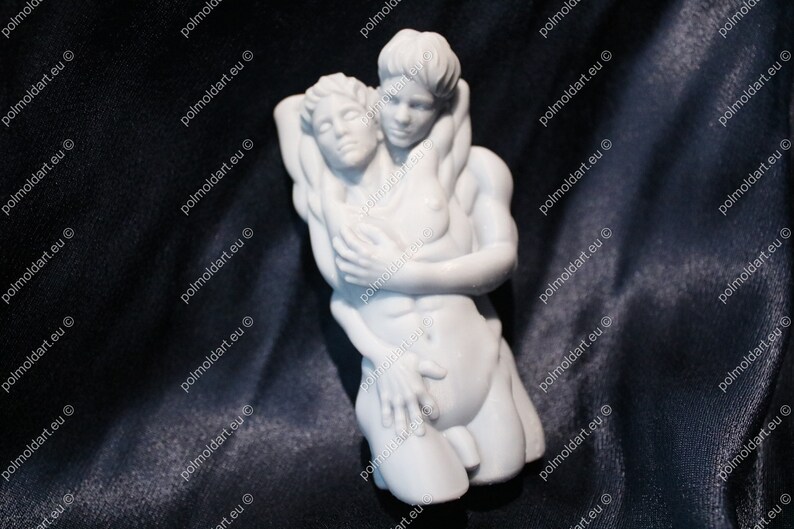 K&ouml;nnte beinhalten: Eine wei&szlig;e Skulptur, die zwei sich umarmende Figuren darstellt. Die Figuren sind nackt, wobei eine Figur die andere st&uuml;tzt. Die Skulptur ist vor einem dunklen Hintergrund platziert, der die Details der Figuren hervorhebt.