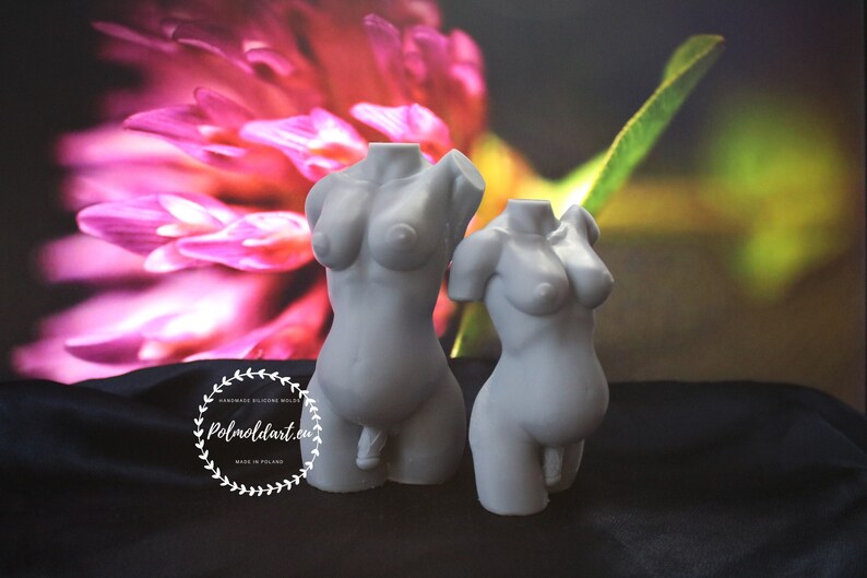 May include: Two grey silicone torso moulds, one with a missing arm. The moulds depict the upper body with breasts and genitalia. The background features a blurred floral image and the text "Polmoldart.eu".