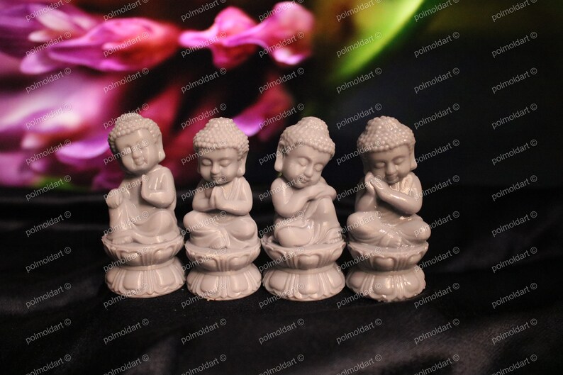 May include: Four small, gray Buddha statues in various meditative poses. Each figure sits atop a lotus flower base. The background features a blurred floral pattern with shades of pink and green.