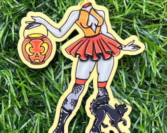 May include: A headless woman sticker with an orange and red outfit, holding a jack-o'-lantern. The sticker features a black wolf and spiderweb stockings. The sticker is on a yellow background.