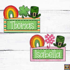 May include: Two green and white striped name tags with a rainbow, shamrock, and leprechaun hat on top. The top tag says "Thomas" and the bottom tag says "Isabella".