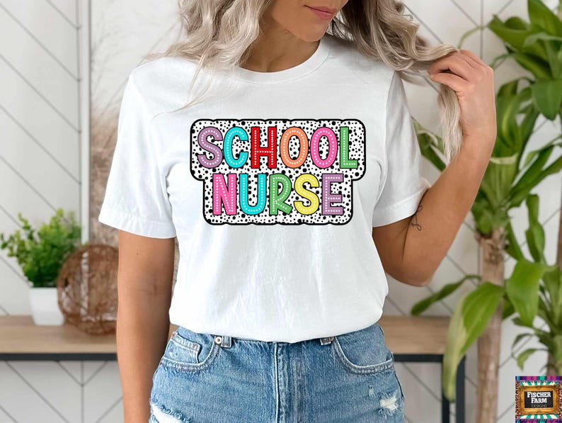 May include: White t-shirt with a colorful "School Nurse" graphic. The graphic has a black and white polka dot background.