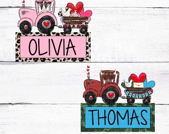 May include: Two personalized name signs featuring Valentine's Day themed tractors. One pink tractor with the name "OLIVIA" on a pink and leopard print background. The other is a red tractor with the name "THOMAS" on a blue and camouflage background.