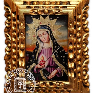 Puede incluir: Una pintura enmarcada de Nuestra Señora de los Dolores, un icono católico que representa a la Virgen María con una expresión de tristeza, sosteniendo un corazón sangrante atravesado por siete espadas. La pintura está sobre un fondo oscuro con estrellas y un halo dorado.