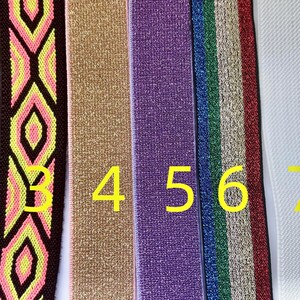 May include: A collection of nine colorful elastic bands. The bands feature various patterns, including geometric designs and solid colors. The colors include pink, brown, blue, yellow, gold, purple, green, white, and light green. These bands are suitable for various crafting projects.