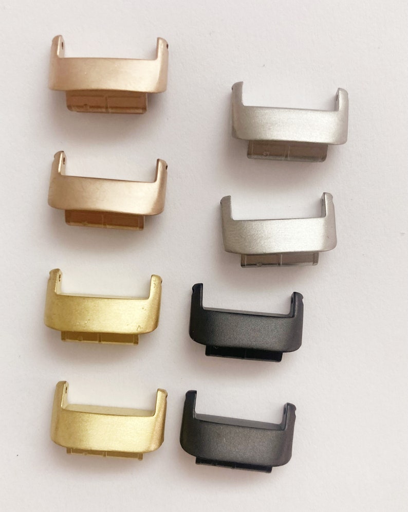 Puede incluir: Ocho cierres de correa de reloj en diferentes colores. Los cierres son de metal y tienen un acabado pulido. Los colores son dorado, plateado, negro y gris.
