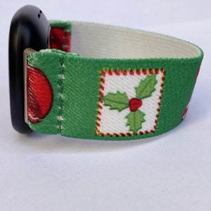 Puede incluir: Una banda de reloj de tem&aacute;tica navide&ntilde;a verde y blanca con un dise&ntilde;o de bayas de acebo rojas. La banda est&aacute; hecha de tela y tiene un respaldo el&aacute;stico blanco.
