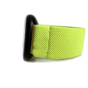 Op de afbeelding: Een zwart horloge met een felgroen elastisch bandje.