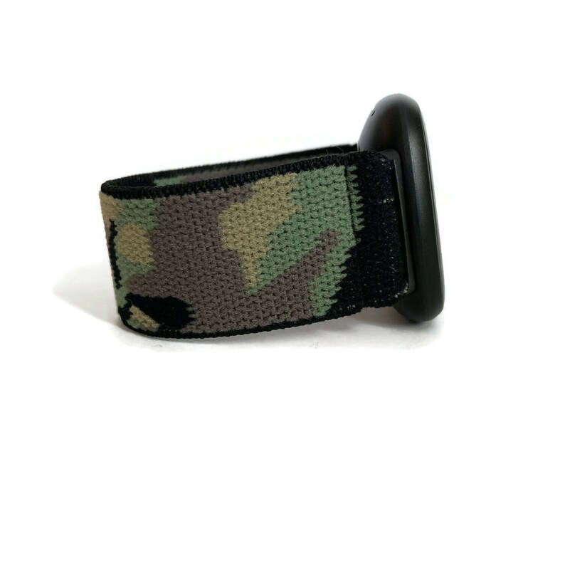 May include: A black watch band with a camouflage pattern. The band is made of a woven fabric and has a black buckle.