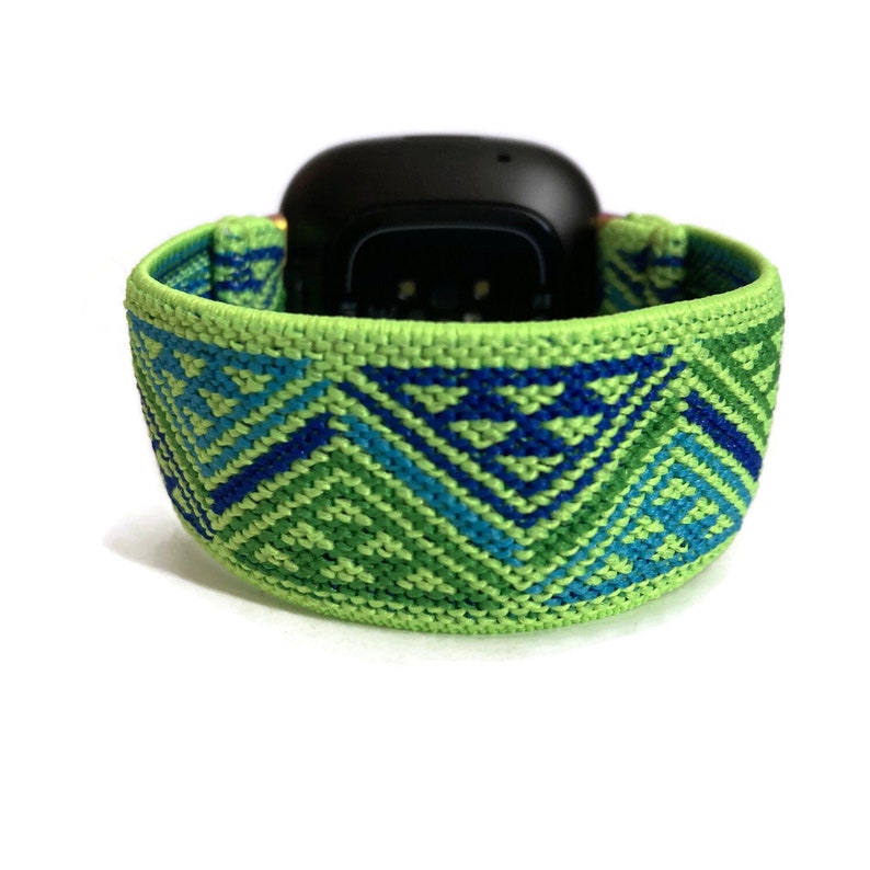 May include: A green and blue patterned woven watch band with a geometric design.