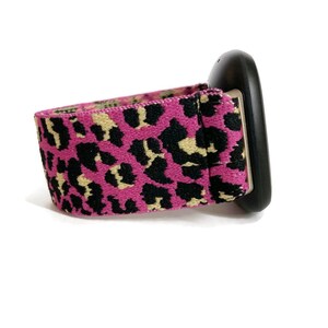 May include: A black and pink leopard print elastic band for a smartwatch.