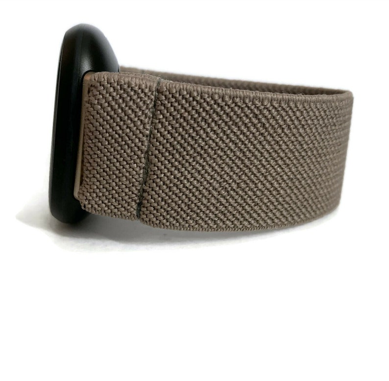 K&ouml;nnte beinhalten: Ein braunes elastisches Armband mit einer schwarzen Metallschnalle.