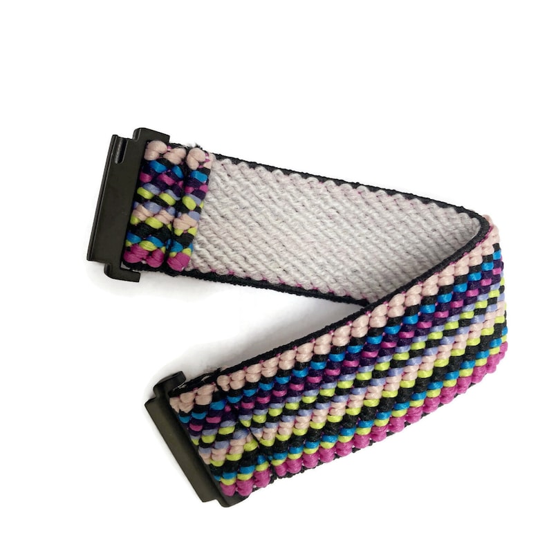 May include: A colorful woven belt with a black buckle. The belt is made of a variety of colors, including pink, blue, green, and yellow.