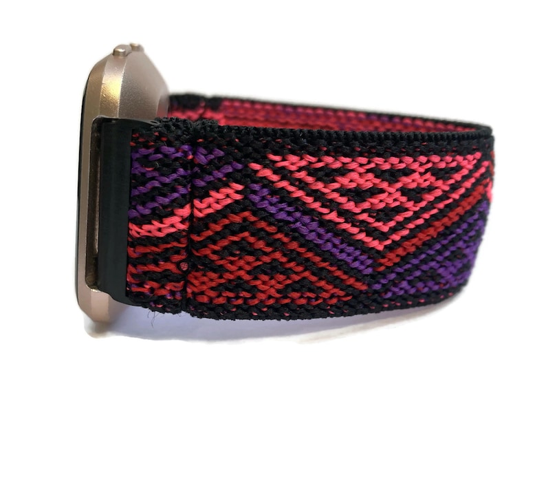 Puede incluir: Una banda el&aacute;stica para reloj con estampado negro, rojo y morado. La banda est&aacute; hecha de una tela tejida con un dise&ntilde;o geom&eacute;trico.
