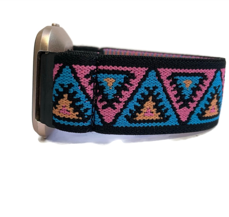 May include: A black elastic watch band with a pink, blue, and orange geometric pattern. The band is designed to fit a smartwatch.